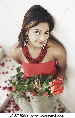 Stock Photo - High angle view of a young woman holding a bouquet of flowers. Fotosearch