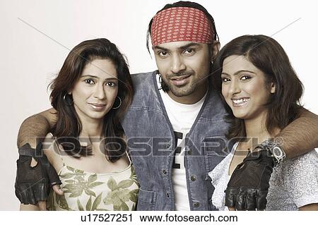 Stock Image - Portrait of a young man with his arms around two young women. Fotosearch