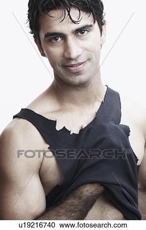 Stock Image - Portrait of a young man with his hand under his vest. Fotosearch