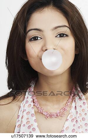 Portrait of a young woman blowing bubble gum View Large Photo Image Stock Photo - Portrait of a young woman blowing bubble gum. Fotosearch