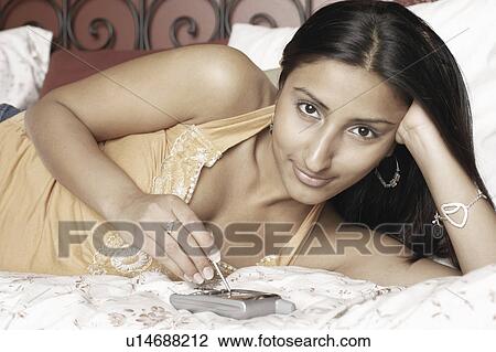 Portrait of a young woman using a mobile phone View Large Photo Image Stock Image - Portrait of a young woman using a mobile phone. Fotosearch