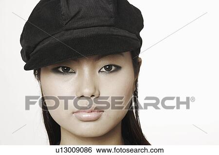 Stock Photograph - Portrait of a young woman wearing a cap. Fotosearch
