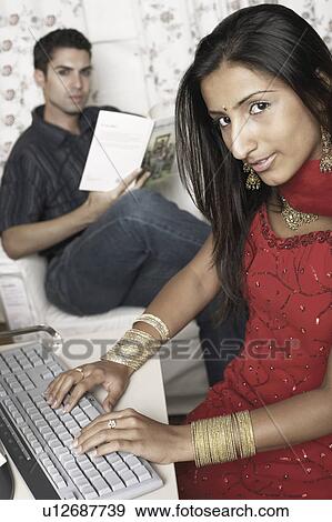 Portrait of a young woman working on a computer View Large Photo Image Stock Photo - Portrait of a young woman working on a computer. Fotosearch