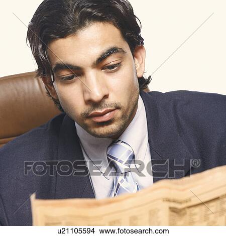 Close-up of a businessman reading a newspaper View Large Photo Image Picture - Close-up of a businessman reading a newspaper. Fotosearch