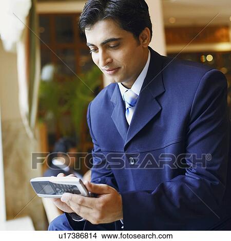 Picture - Close-up of a businessman using a mobile phone. Fotosearch