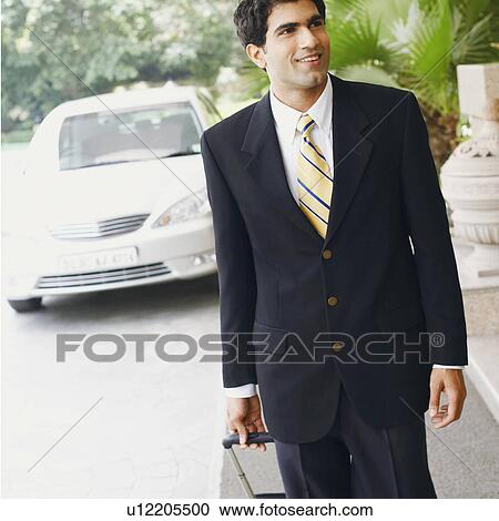 Close-up of a businessman walking with a suitcase View Large Photo Image Stock Image - Close-up of a businessman walking with a suitcase. Fotosearch