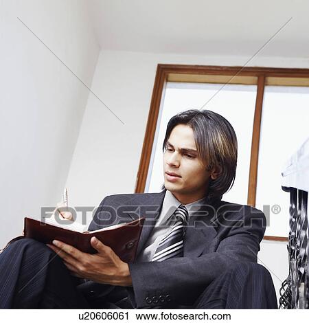Stock Image - Low angle view of a businessman writing in a personal organizer. Fotosearch