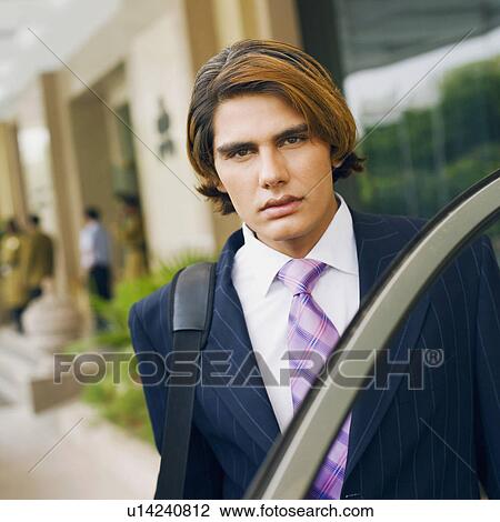 Stock Image - Portrait of a businessman carrying a bag. Fotosearch