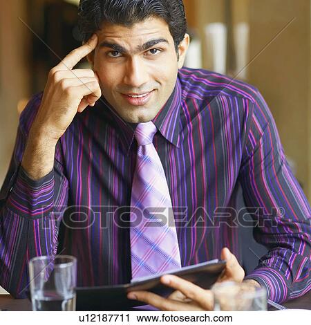 Portrait of a businessman sitting in a restaurant and smiling View Large Photo Image Stock Image - Portrait of a businessman sitting in a restaurant and smiling. Fotosearch