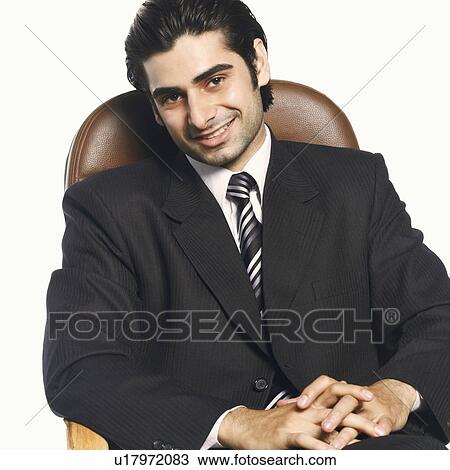 Stock Image - Portrait of a businessman smiling with his hands clasped. Fotosearch