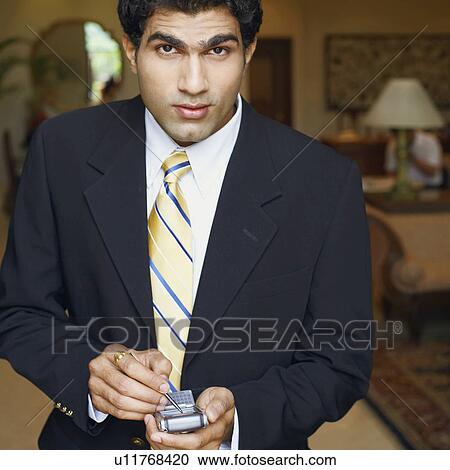 Stock Image - Portrait of a businessman using a personal data assistant. Fotosearch