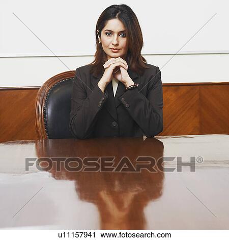Stock Image - Portrait of a businesswoman sitting in a conference room. Fotosearch