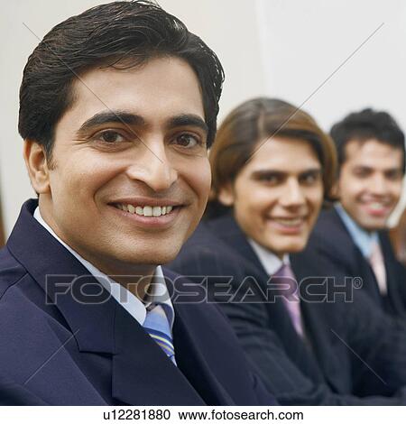 Stock Image - Portrait of three businessmen smiling. Fotosearch