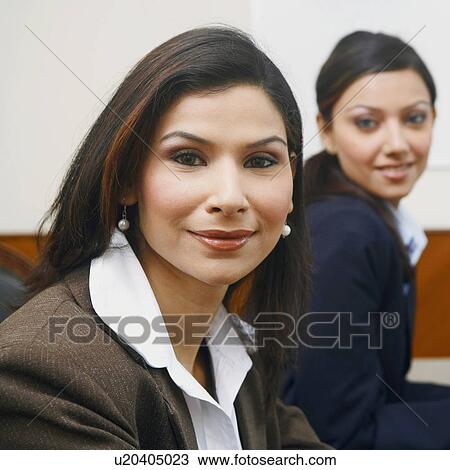 Stock Image - Portrait of two businesswomen smiling. Fotosearch