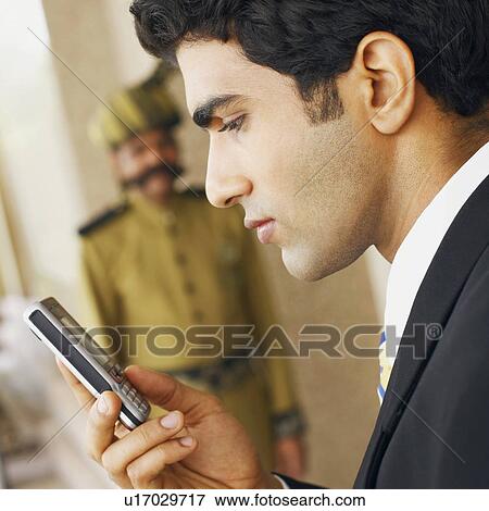 Side profile of a businessman using a mobile phone View Large Photo Image Stock Photo - Side profile of a businessman using a mobile phone. Fotosearch