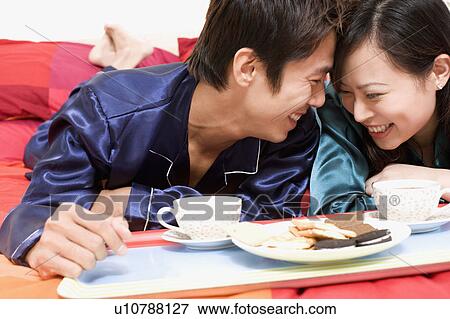 Close-up of a couple lying on the bed View Large Photo Image Stock Photo - Close-up of a couple lying on the bed. Fotosearch