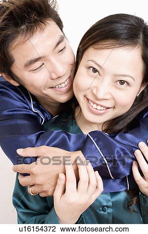 Close-up of a mid adult man hugging a young woman from behind View Large Photo Image Stock Image - Close-up of a mid adult man hugging a young woman from behind. Fotosearch