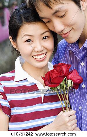 Close-up of a young couple holding a bunch of roses View Large Photo Image Stock Image - Close-up of a young couple holding a bunch of roses. Fotosearch