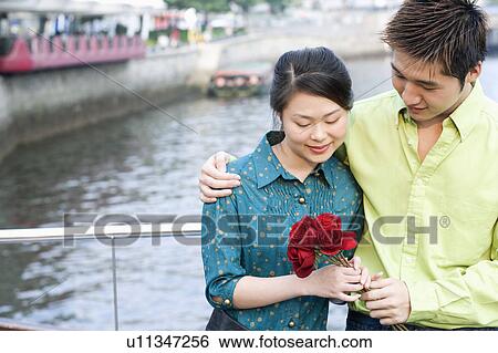 Close-up of a young couple holding a bunch of roses View Large Photo Image Stock Photograph - Close-up of a young couple holding a bunch of roses. Fotosearch