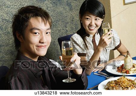 Close-up of a young couple holding glasses of champagne View Large Photo Image Stock Photo - Close-up of a young couple holding glasses of champagne. Fotosearch