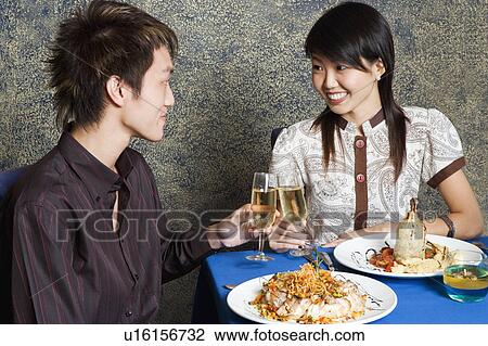 Stock Image - Close-up of a young couple toasting with champagne. Fotosearch