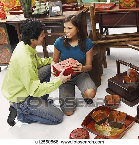Stock Photograph - High angle view of a young couple choosing merchandise in a store. Fotosearch