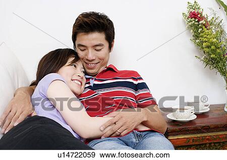 Mid adult man and a young woman lying on a couch and smiling View Large Photo Image Stock Photo - Mid adult man and a young woman lying on a couch and smiling. Fotosearch