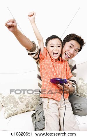 Portrait of a boy and his father playing a video game View Large Photo Image Stock Image - Portrait of a boy and his father playing a video game. Fotosearch