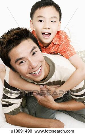 Portrait of a boy riding piggyback on his father View Large Photo Image Stock Photo - Portrait of a boy riding piggyback on his father. Fotosearch