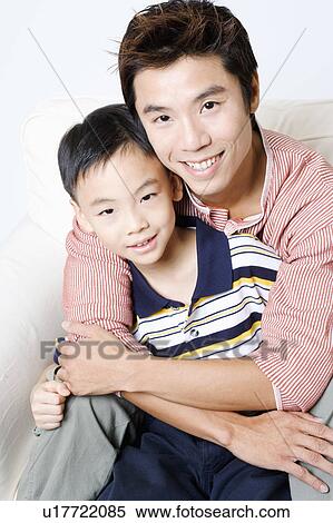 Portrait of a mid adult man hugging his son from behind View Large Photo Image Stock Photography - Portrait of a mid adult man hugging his son from behind. Fotosearch