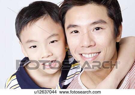 Picture - Portrait of a mid adult man smiling with his son. Fotosearch