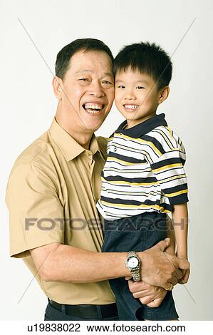 Portrait of a senior man carrying his grandson View Large Photo Image Stock Image - Portrait of a senior man carrying his grandson. Fotosearch