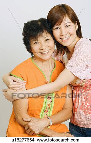 Portrait of a young woman embracing her mother View Large Photo Image Picture - Portrait of a young woman embracing her mother. Fotosearch