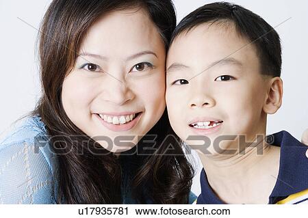 Portrait of a young woman smiling with her son View Large Photo Image Stock Image - Portrait of a young woman smiling with her son. Fotosearch