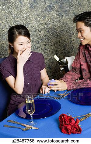 Young man giving a gift to a young woman View Large Photo Image Stock Photograph - Young man giving a gift to a young woman. Fotosearch