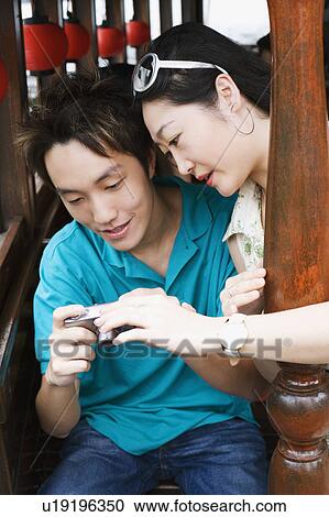 Stock Image - Close-up of a young couple looking at a digital camera. Fotosearch