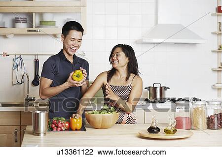 Close-up of a young man and a young woman standing and holding yellow bell peppers View Large Photo Image Stock Image - Close-up of a young man and a young woman standing and holding yellow bell peppers. Fotosearch