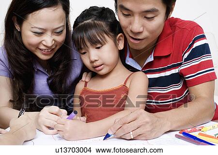 Close-up of parents drawing on paper with their daughter View Large Photo Image Picture - Close-up of parents drawing on paper with their daughter. Fotosearch