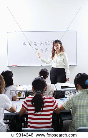 Stock Photograph - Professor giving lecture to students in the classroom. Fotosearch
