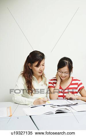 Stock Photography - Professor teaching a student in the classroom. Fotosearch