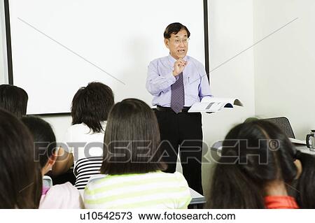 Stock Image - Teacher teaching in a classroom. Fotosearch