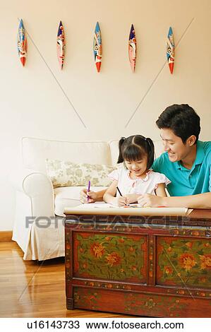 Young man teaching his daughter to color View Large Photo Image Stock Image - Young man teaching his daughter to color. Fotosearch