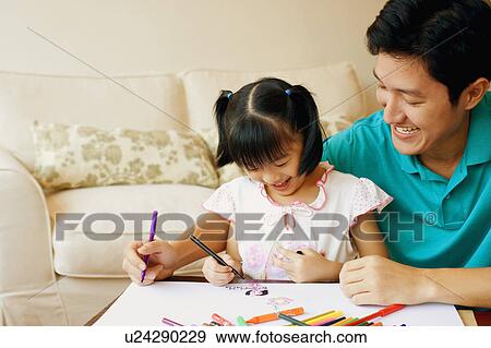 Young man teaching his daughter to color View Large Photo Image Stock Photo - Young man teaching his daughter to color. Fotosearch