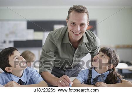 Male teacher correcting student work View Large Photo Image Stock Photography - Male teacher correcting student work. Fotosearch