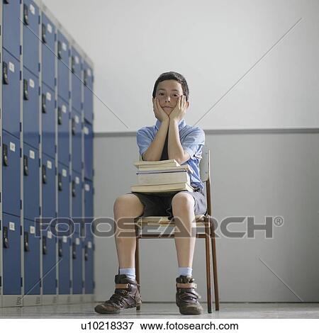 Stock Photo - School boy sitting with books. Fotosearch