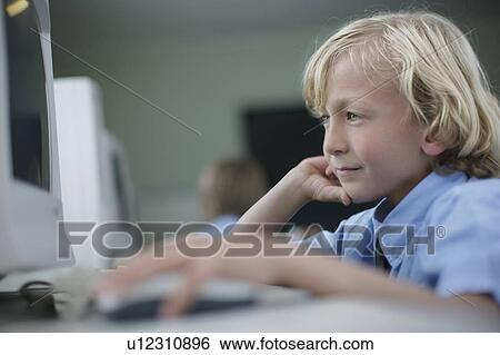 Stock Photograph - School boy using computer. Fotosearch