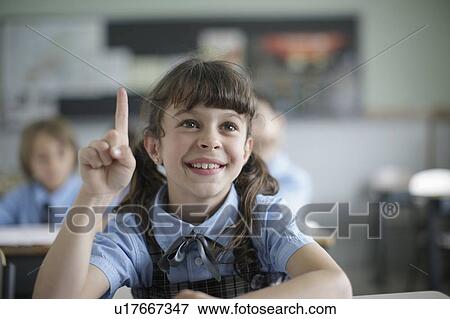 Stock Photo - School girl raising hand in class. Fotosearch