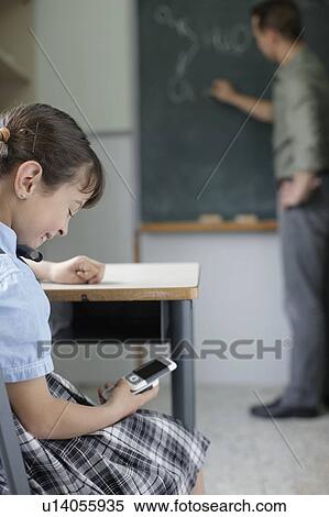 School girl texting in class View Large Photo Image Stock Photography - School girl texting in class. Fotosearch