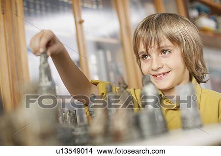 Picture - Young boy playing chess. Fotosearch
