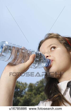 Stock Photograph - Young girl drinking from bottle. Fotosearch